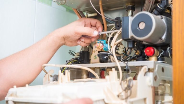 Closeup of a technician performing furnace repair inside a furnace system in a Los Angeles home.