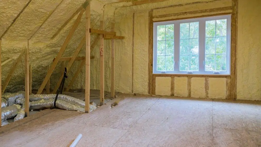 A finished attic with spray foam insulation on the walls and roof, overlooking a large window in West Hollywood, CA.