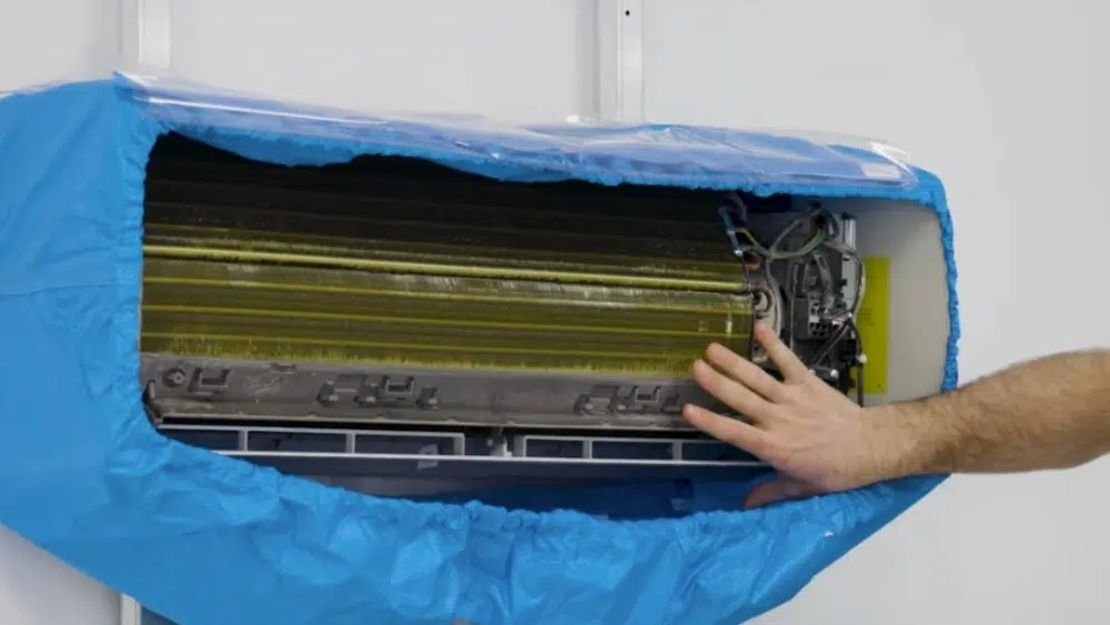 Indoor split AC unit being cleaned with a protective bag for air conditioner maintenance in Los Angeles County, CA.