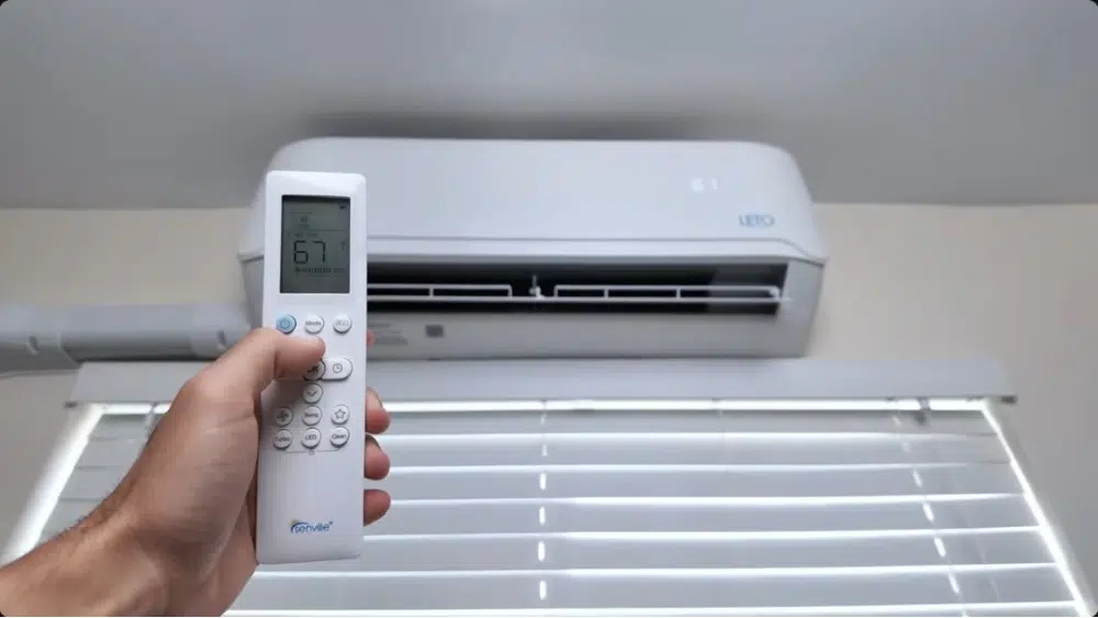 Homeowner using a remote to operate a ductless mini split AC unit installed in Santa Clarita, CA
