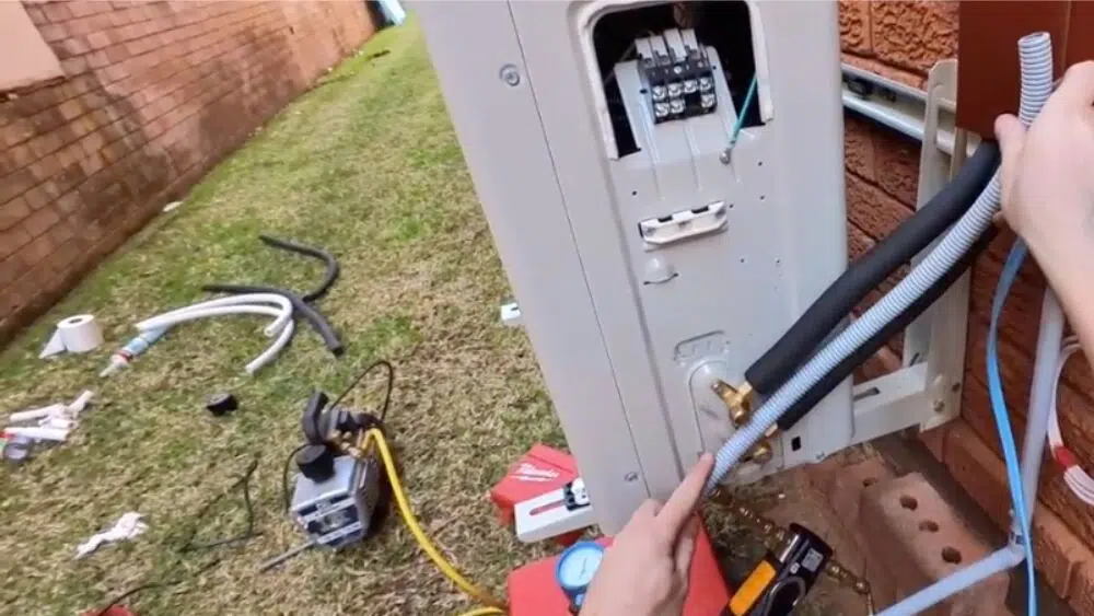 Technician installing refrigerant and electrical lines for a ductless mini split system in Santa Monica, CA, ensuring safe and efficient setup.