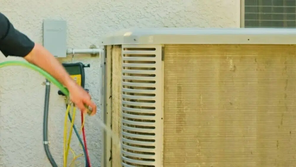 Technician washing air conditioner unit coils as part of emergency AC repair and maintenance in Santa Monica.