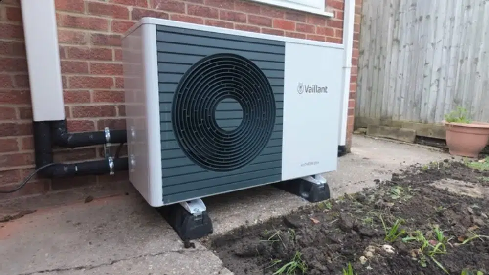 Heat pump installation Santa Clarita CA outdoor Vaillant unit positioned next to brick home for optimal performance.