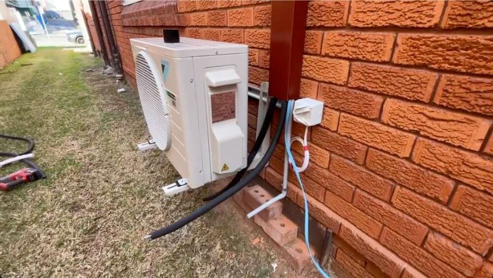 Outdoor component of an energy-efficient mini split system mounted on a brick wall in Santa Monica, CA.