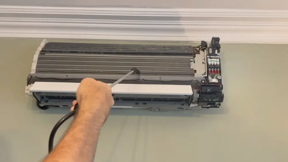 Technician cleaning the interior unit of a ductless mini split heat pump, highlighting detailed maintenance in Santa Monica, CA.