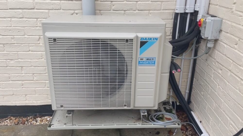Outdoor Daikin heat pump unit installed on a brick wall, showcasing energy-efficient air source heat pump installation in Santa Monica, CA.