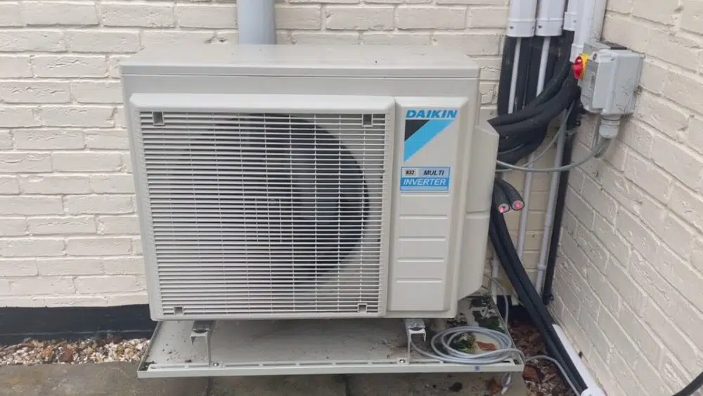Outdoor Daikin heat pump unit installed on a brick wall, showcasing energy-efficient air source heat pump installation in Santa Monica, CA.