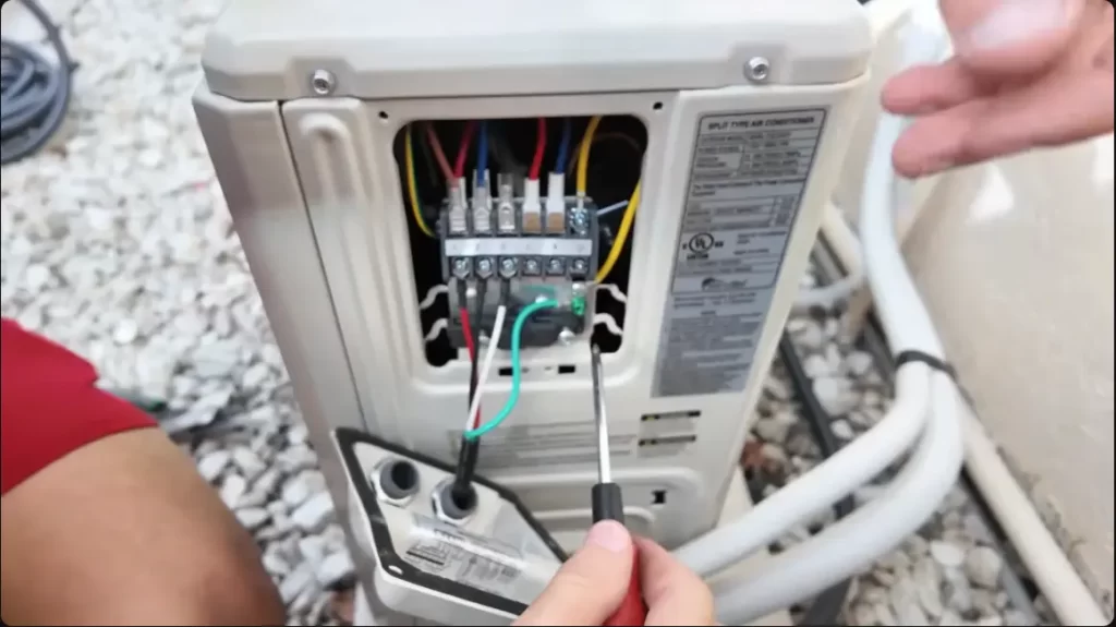 HVAC technician wiring the outdoor mini split air conditioner during professional installation in Agoura Hills, CA.
