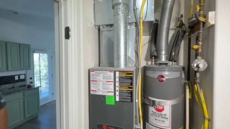 Indoor dual fuel furnace Thousand Oaks installed next to a Rheem water heater with ductwork and gas lines in a residential utility closet.