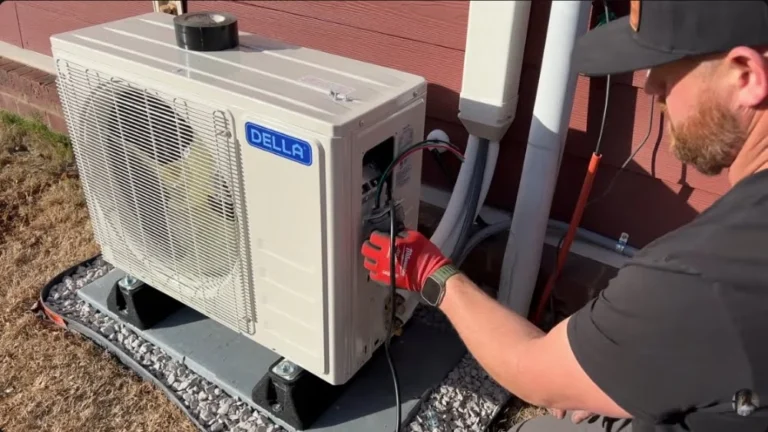 HVAC technician in work gloves connecting electrical wiring on a Della outdoor condenser during Mini-split AC installation in Granada Hills.