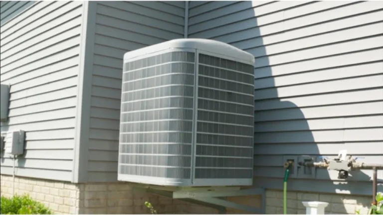 Wall-mounted outdoor condenser unit of a dual fuel heat pump Thousand Oaks residential installation on house siding.