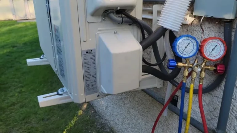 HVAC manifold gauges connected to an outdoor ductless mini-split unit for refrigerant pressure testing during installation.