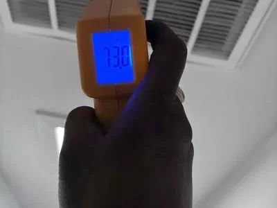 HVAC technician checking AC airflow and temperature performance in Sherman Oaks CA.