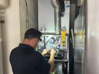 HVAC technician diagnosing and repairing internal furnace components in Agoura Hills, CA.
